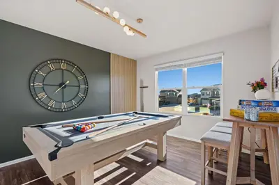 a pool table in a room with a clock on the wall at NEW! Family-friendly Home with Pool Table, King Beds in Windsor