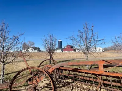 an old rusty bench in a field with a barn at NEW! Family-friendly Home with Pool Table, King Beds in Windsor