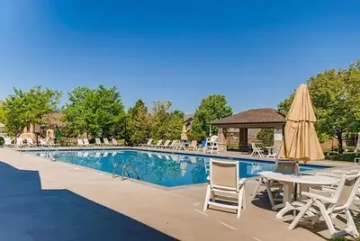 a pool with chairs and a table and a umbrella at NEW! Family-friendly Home with Pool Table, King Beds in Windsor