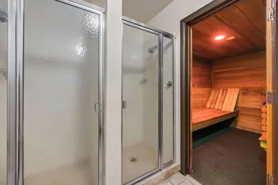 a sauna with a glass shower and a bench at The Fox Den in Old Town! Pool, Sauna & Game Room in Fort Collins