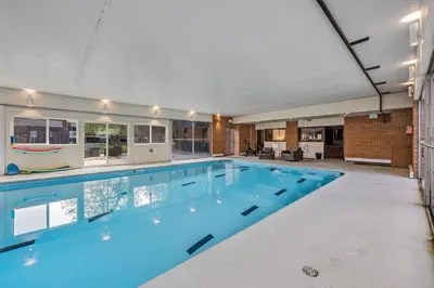 a large swimming pool in a large room with at The Fox Den in Old Town! Pool, Sauna & Game Room in Fort Collins