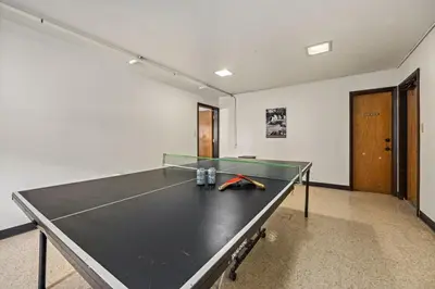 a ping pong table in a room with a ping pong ball at The Fox Den in Old Town! Pool, Sauna & Game Room in Fort Collins