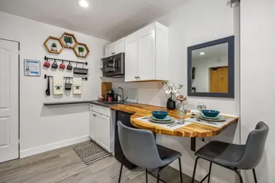 a kitchen with a wooden table and chairs at The Fox Den in Old Town! Pool, Sauna & Game Room in Fort Collins