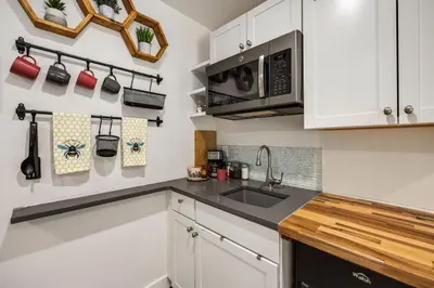 a kitchen with a sink and a microwave at The Fox Den in Old Town! Pool, Sauna & Game Room in Fort Collins