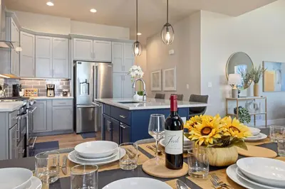 a kitchen with a table with glasses and a bottle of wine at NEW! Elegant Home near TPC Golf Course & Trails in Loveland