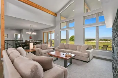 a living room with couches and a table at Luxury Home with Spectacular Rocky Mountain Views! in Eaton