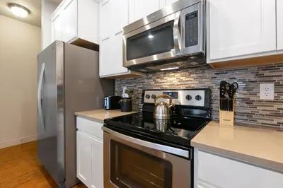 a kitchen with a stove and a microwave at Urban Oasis near Breweries & Old Town - Free Bikes in Fort Collins
