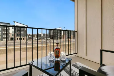 a bottle of alcohol sitting on a table on a balcony at Urban Oasis near Breweries & Old Town - Free Bikes in Fort Collins