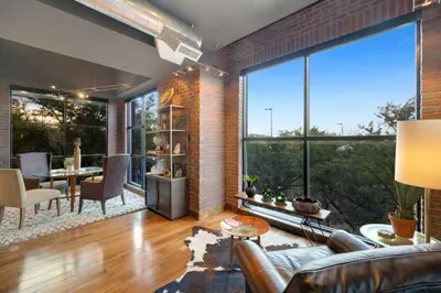 a living room with a couch and a large window at Penthouse with Mountain Views in the Heart of Old Town in Fort Collins