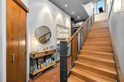a staircase in a home with wooden floors and a mirror at Penthouse with Mountain Views in the Heart of Old Town in Fort Collins