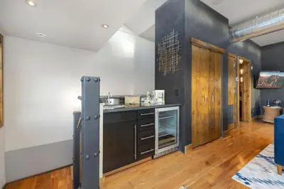 a kitchen with a counter in a room with wooden floors at Penthouse with Mountain Views in the Heart of Old Town in Fort Collins