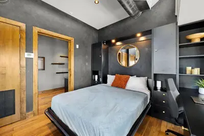 a bedroom with a bed and a mirror on the wall at Penthouse with Mountain Views in the Heart of Old Town in Fort Collins