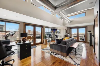 a living room with a couch and a desk at Penthouse with Mountain Views in the Heart of Old Town in Fort Collins
