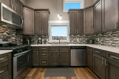 a kitchen with dark wood cabinets and a window at Luxury Living - Walk to Poudre Trail and Old Town! in Fort Collins