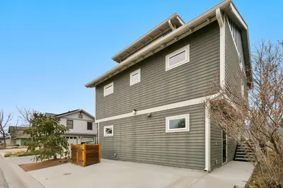 a large gray house with a garage at Luxury Living - Walk to Poudre Trail and Old Town! in Fort Collins