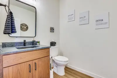 a bathroom with a toilet and a mirror at Ski-InandSki-Out Granby Ranch Retreat Pool Access! in Granby