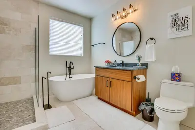 a bathroom with a tub and a toilet and a mirror at Ski-InandSki-Out Granby Ranch Retreat Pool Access! in Granby