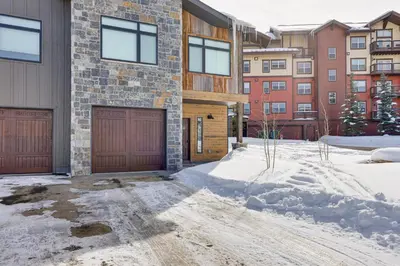 a house with two garage doors in the snow at Ski-InandSki-Out Granby Ranch Retreat Pool Access! in Granby