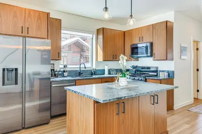 a kitchen with wooden cabinets and stainless steel appliances at Ski-InandSki-Out Granby Ranch Retreat Pool Access! in Granby