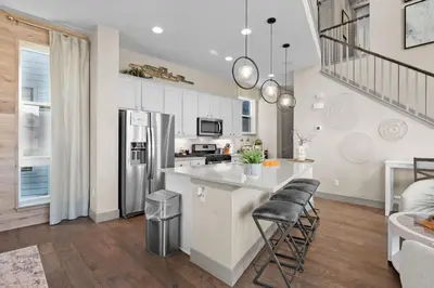 a kitchen with white cabinets and a refrigerator at Orleans Street - Aurora in Aurora
