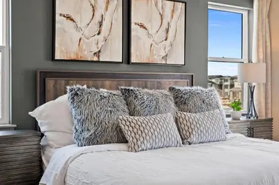 a bedroom with a bed with pillows on it at Orleans Street - Aurora in Aurora