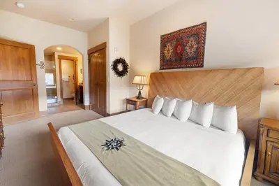a bedroom with a large white bed with a wooden headboard at 3Br Ski-in Ski-out-On Mountain-Lone Eagle 3053 condo in Dillon
