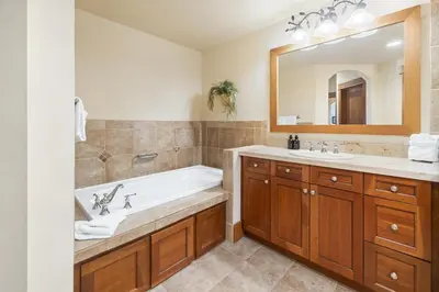 a bathroom with a tub and a sink and a mirror at 3Br Ski-in Ski-out-On Mountain-Lone Eagle 3053 condo in Dillon