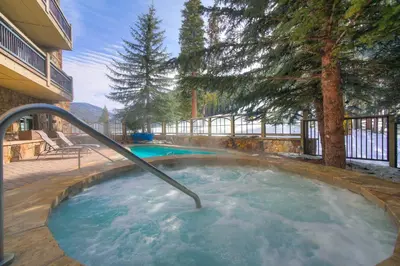 a hot tub with a metal rail in a yard at 3Br Ski-in Ski-out-On Mountain-Lone Eagle 3053 condo in Dillon