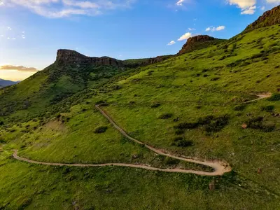 a dirt road on a grassy hill with a mountain at Unbeatable Location Golden Condo - Walk Everywhere in Golden