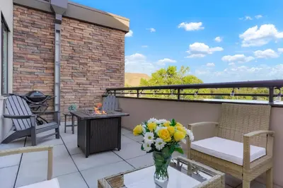 a balcony with a table and chairs and a vase of flowers at Golden Condo Patio with MTN Views Walk to DT Golden and School of Mines in Golden