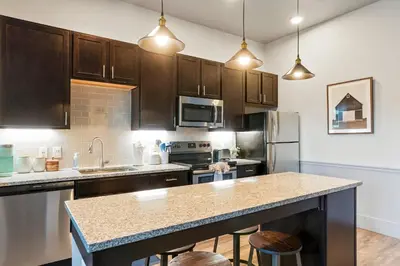 a kitchen with wooden cabinets and a counter top at Golden Condo Patio with MTN Views Walk to DT Golden and School of Mines in Golden