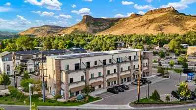 an apartment building with a mountain in the background at Golden Condo Patio with MTN Views Walk to DT Golden and School of Mines in Golden