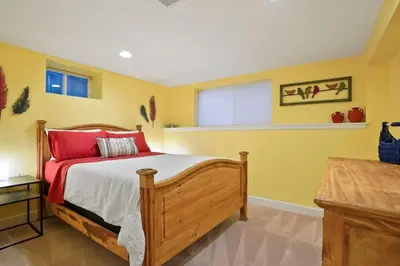 a bedroom with a wooden bed and yellow walls at Shakedown St HOT TUB Fire Pit and 4 Miles to DT in Denver