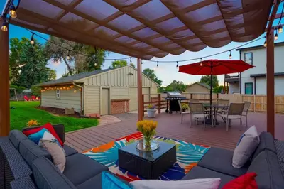 a patio with a couch and a table and an umbrella at Shakedown St HOT TUB Fire Pit and 4 Miles to DT in Denver