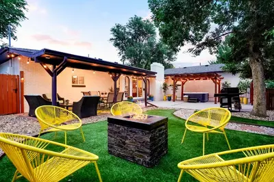 a group of yellow chairs and a table in a yard at Unforgettable Stay HOT TUB and Fire Pit and 4 Miles to DT Denver in Denver