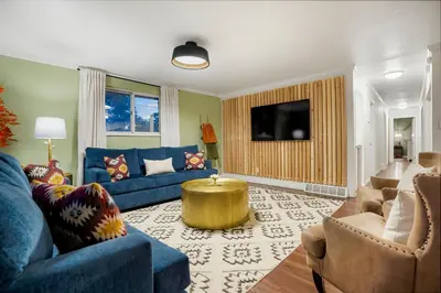 a living room with a blue couch and a tv at Unforgettable Stay HOT TUB and Fire Pit and 4 Miles to DT Denver in Denver