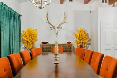 a dining room with a table with a candle and orange chairs at Unforgettable Stay HOT TUB and Fire Pit and 4 Miles to DT Denver in Denver