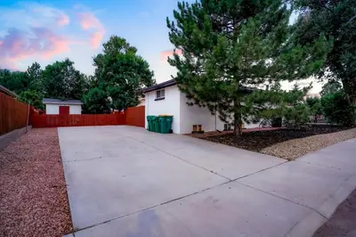 a driveway in front of a house with a fence at Unforgettable Stay HOT TUB and Fire Pit and 4 Miles to DT Denver in Denver