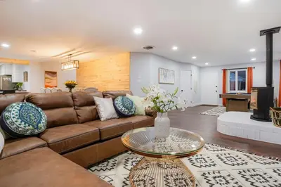 a living room with a brown couch and a table at One of a Kind Home with HOT TUB Pool Table and Fire Pit 4 Miles to DT in Denver