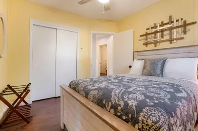 a bedroom with a large bed and yellow walls at One of a Kind Home with HOT TUB Pool Table and Fire Pit 4 Miles to DT in Denver
