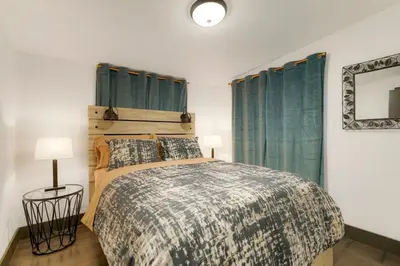 a bedroom with a bed and two lamps and a mirror at Best Experience in Denver HOT TUB and FIRE PIT 4 miles to DT in Denver