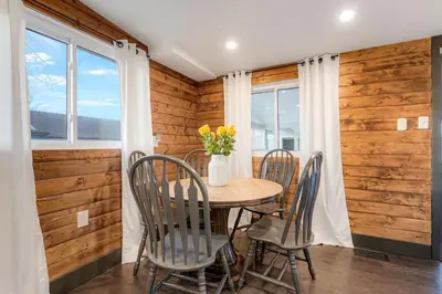 a dining room with a table and chairs and windows at Best Experience in Denver HOT TUB and FIRE PIT 4 miles to DT in Denver