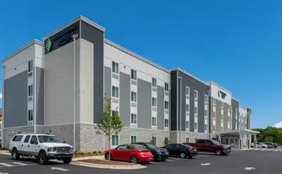 a large building with cars parked in a parking lot at WoodSpring Suites Denver Commerce City in Commerce City
