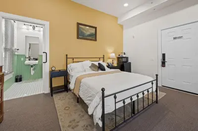 a bedroom with a bed and a bathroom with a sink at Club Hotel in Idaho Springs