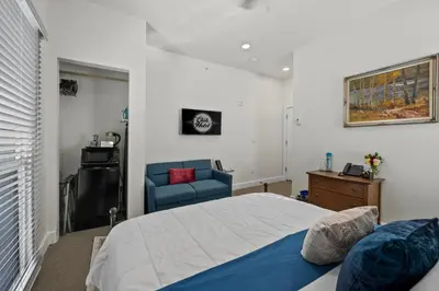 a bedroom with a bed and a blue chair at Club Hotel in Idaho Springs