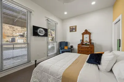 a bedroom with a bed and a dresser and a window at Club Hotel in Idaho Springs