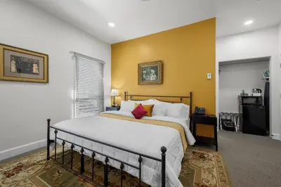 a bedroom with a bed and a yellow wall at Club Hotel in Idaho Springs