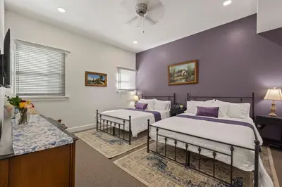 two beds in a room with purple walls at Club Hotel in Idaho Springs
