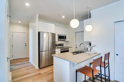 a kitchen with white cabinets and a stainless steel refrigerator at 2 Mi to Fraser Tubing Hill Condo with Fireplace! in Fraser