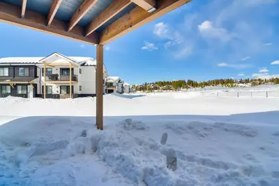 a snow covered patio with a house in the background at 2 Mi to Fraser Tubing Hill Condo with Fireplace! in Fraser